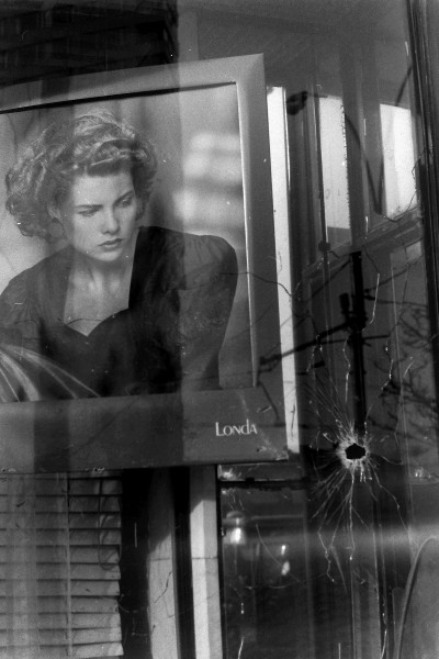 По-моему, самый интересный кадр. Девушка-модель с плаката смотрит на разбитое от выстрела стекло...